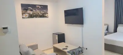 a living room with a bed and a tv on a wall at مراسيم للشقق الفندقية in Amman