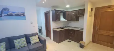 a living room with a couch and a kitchen at مراسيم للشقق الفندقية in Amman