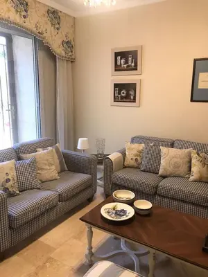a living room with two couches and a coffee table at Happy Family Home with Spacious Garden in Amman