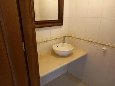 a bathroom with a white sink and a mirror at Happy Family Home with Spacious Garden in Amman