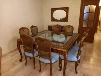 a dining room table with chairs and a mirror at Happy Family Home with Spacious Garden in Amman