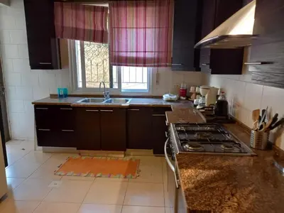 a kitchen with a stove and a sink and a window at Happy Family Home with Spacious Garden in Amman