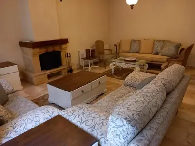 a living room with a couch and a fireplace at Happy Family Home with Spacious Garden in Amman
