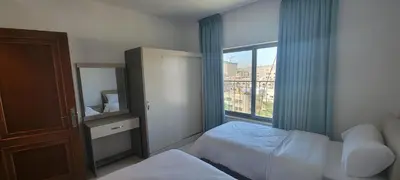 a hotel room with two beds and a window at العبد للشقق الفندقية in Amman