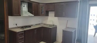 a kitchen with wooden cabinets and a sink at العبد للشقق الفندقية in Amman