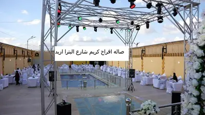 a banquet hall with white chairs and a pool at Kareem celebrations Hall صاله افراح in Irbid