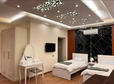 a bedroom with two beds and a mirror and a sink at Kareem celebrations Hall صاله افراح in Irbid