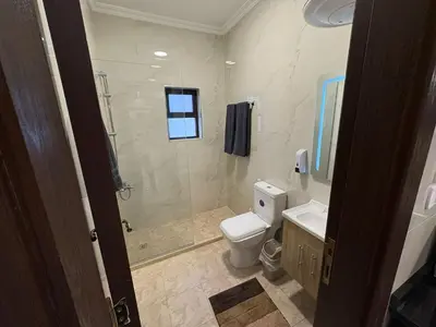 a bathroom with a shower and a toilet and a sink at Third circle Luxury Hotel apartment New in Amman