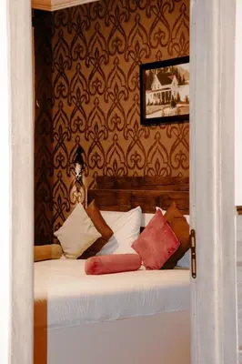 a bedroom with a bed with pillows on it at Balcony Hotel in Amman