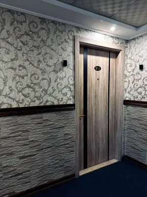 a wooden door in a room with wallpaper at Balcony Hotel in Amman