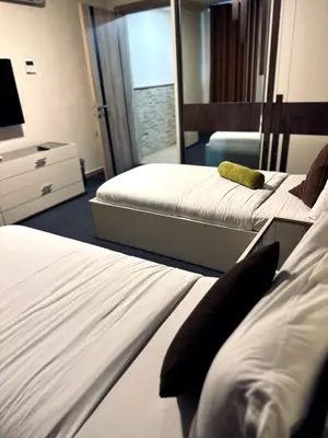 a hotel room with two beds and a mirror at Balcony Hotel in Amman