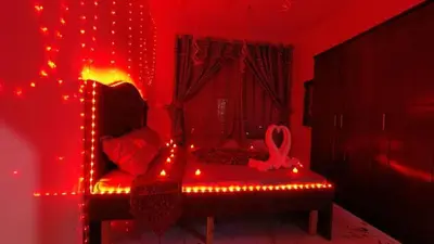 a room with a red room with a chair with lights at الرمثا هوتل in Ar Ramthā