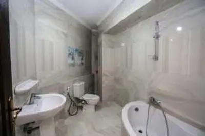 a white bathroom with a sink and a tub and a toilet at الرمثا هوتل in Ar Ramthā