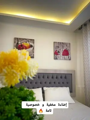 a bedroom with a bed with two pictures on the wall at Falcon Real Estate in Amman