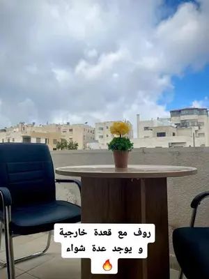 a table and a chair with a plant on it at Falcon Real Estate in Amman