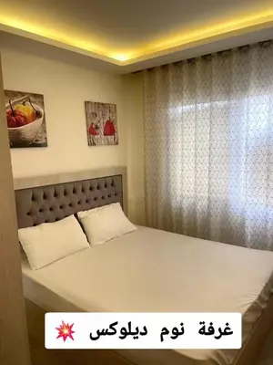 a bedroom with a bed and a window at Falcon Real Estate in Amman