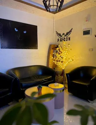 a lobby with two leather couches and a cat on the wall at Falcon Real Estate in Amman