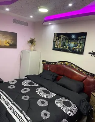 a bedroom with a bed with a black and white comforter at Falcon Real Estate in Amman