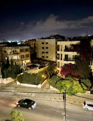 a car driving down a city street at night at Falcon Real Estate in Amman