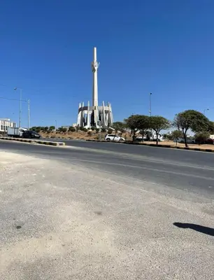 an empty road with a monument in the background at Falcon Real Estate in Amman