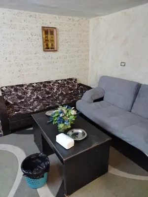a living room with a couch and a table at شقة الراحة والسعادة economic comfortable flat first floor in Amman