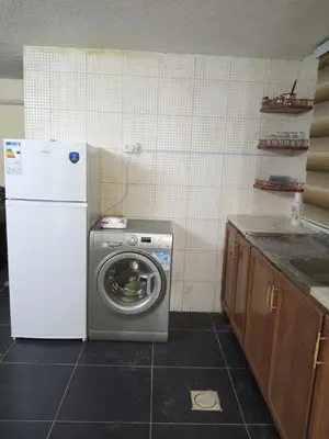 a kitchen with a washing machine and a white refrigerator at شقة الراحة والسعادة economic comfortable flat first floor in Amman