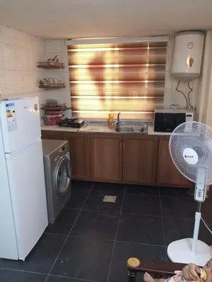 a kitchen with a refrigerator and a washing machine at شقة الراحة والسعادة economic comfortable flat first floor in Amman