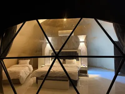 two beds in a room with a window at Wadi Rum Sunset camp in Disah