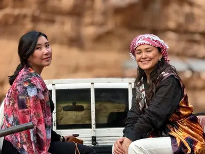 two women sitting next to each other at Wadi Rum Sunset camp in Disah