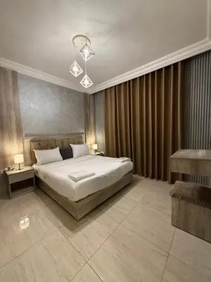 a bedroom with a large bed and a table at unique 2bedroom at abdoun 007 in Amman