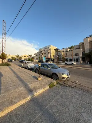 a row of cars parked on the side of a street at unique 2bedroom at abdoun 007 in Amman