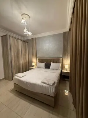 a bedroom with a bed with two tables and two lamps at unique 2bedroom at abdoun 007 in Amman