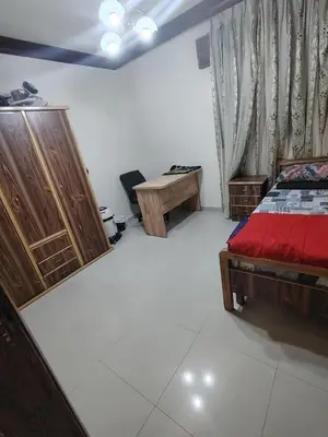 a bedroom with a bed and a desk and a table at شقة مفروشة مدخل مستقل in Jurf ad Darāwīsh