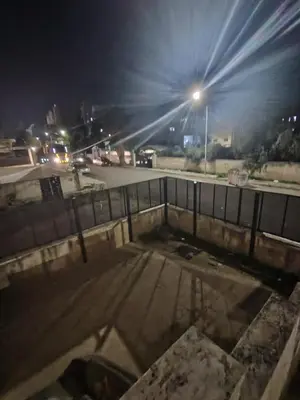 an empty parking lot at night with a street light at شقة مفروشة مدخل مستقل in Jurf ad Darāwīsh