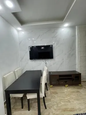 a dining room with a table and a television on a wall at Seventh circle stay - Cozy &Chic in Amman