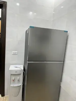 a stainless steel refrigerator in a kitchen with a trash can at Seventh circle stay - Cozy &Chic in Amman