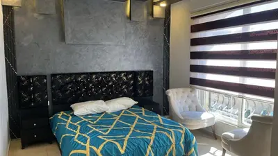 a bedroom with a bed and a chair at Izz AlDin Tamimi St, Deluxe Jubaiha Furnished Apartment,3rd Edition in Amman