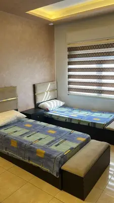 two beds sitting in a room with a window at Izz AlDin Tamimi St, Deluxe Jubaiha Furnished Apartment,3rd Edition in Amman