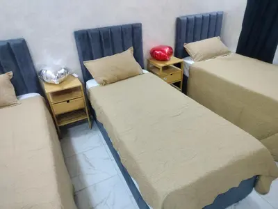 a room with two beds and two night stands at Furnished apartments for rent 1 in Aqaba