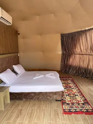 a bedroom with a white bed and a rug at Rum gate camp Fares in Disah