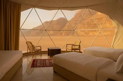 a room with two beds and a large window at Wadi Rum Quiet luxury camp in Wadi Rum