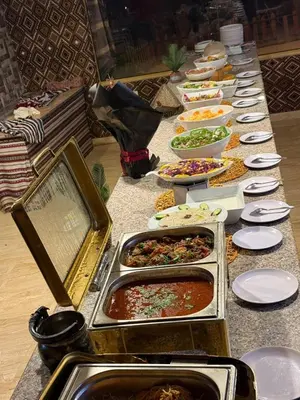 a long buffet line with many different types of food at Wadi Rum Quiet luxury camp in Wadi Rum