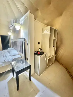 a small room with a bed and a table at Wadi Rum ZAAD luxury Camp in Wadi Rum