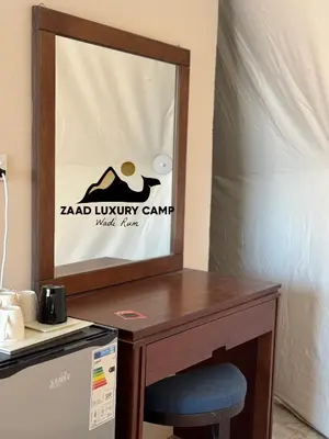 a table with a chair and a sign on it at Wadi Rum ZAAD luxury Camp in Wadi Rum