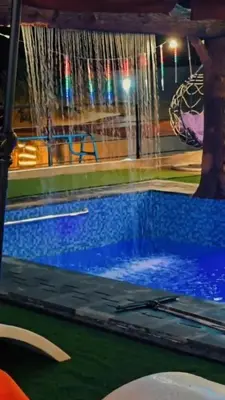 a swimming pool with water falling over it at منتجع ومزرعة برجيل السد in Ballās