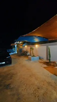 a car parked in front of a building at night at منتجع ومزرعة برجيل السد in Ballās