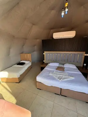 a bedroom with two beds in a room at Wadi Rum Hala camp in Wadi Rum