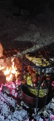 a grill with a bunch of food and a fire at Jordan trail from dana to petra in Dana