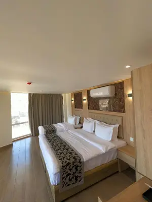 a large bedroom with a large bed with white sheets at Grand Season Hotel in Aqaba