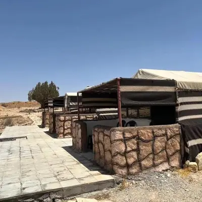 a building with a tent and a stone wall at Dana Hiking Camp - Dana Nature Reserve in Dana